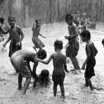 Children enjoying themselves while playing in the rain in India.