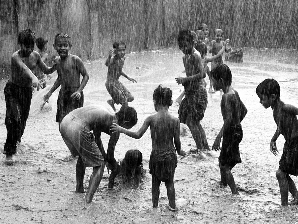 Children enjoying themselves while playing in the rain in India.