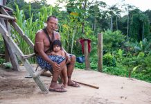 An indigenous man and child featured in the documentary. Image by Michael Clark/Gravitas Ventures.