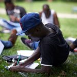 An unaccompanied foreign minor does lessons provided by a volunteer in a park in Toulouse, France, October 2017. Alain Pitton/NurPhoto via Getty Images