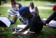 An unaccompanied foreign minor does lessons provided by a volunteer in a park in Toulouse, France, October 2017. Alain Pitton/NurPhoto via Getty Images
