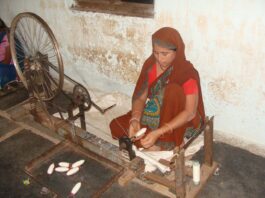 A lady using a spinning wheel to make coarse cotton thread/ Image:Pixabay